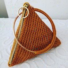 a brown purse sitting on top of a white bed