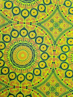 an intricate yellow and blue pattern with circles on it's center, as well as the