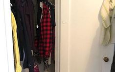 an open closet with clothes hanging on the door and shoes in the closet next to it