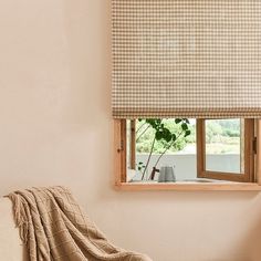 a living room with a couch, window and blanket on the floor in front of it