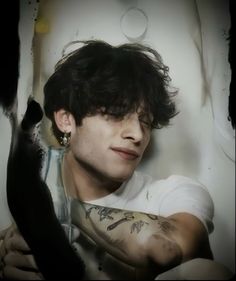 a man with black hair and tattoos on his arm