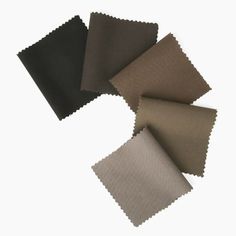 four different colors of fabric on top of each other, one black and one brown