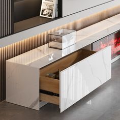 a white table with drawers and a magazine rack on it's side wall next to a fireplace