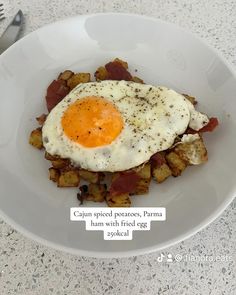 a white plate topped with hash browns and an egg