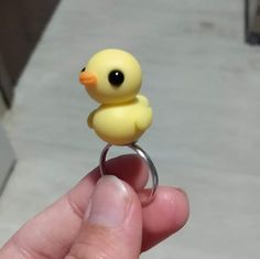 a small yellow rubber ducky ring held in someone's hand