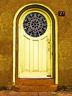 a yellow door with a round window on it