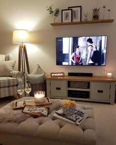 a living room filled with furniture and a flat screen tv on top of a wall