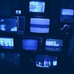 several televisions are stacked up in a dark room