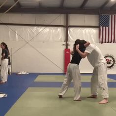 two people standing in a gym with one holding the other's head while others stand around