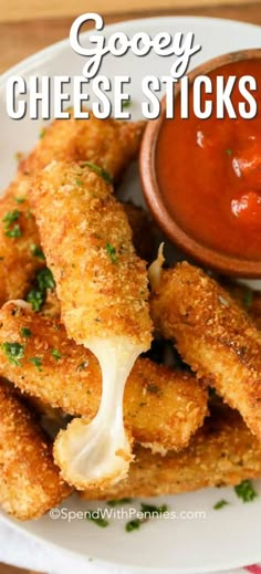 some chicken sticks are on a plate with dipping sauce