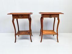 two wooden end tables with one drawer open and the other closed on both sides, sitting side by side