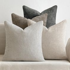 three pillows sitting on top of a couch