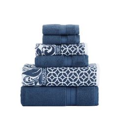 four towels stacked on top of each other in blue and white patterns, with one towel folded