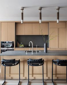 a kitchen with three bar stools next to an island