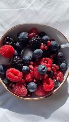 berries, raspberries and blueberries in a bowl on a white tablecloth