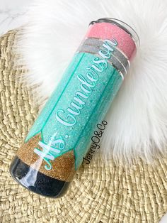 a can with glitter on it sitting on top of a straw hat next to a white fur