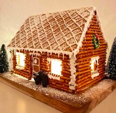 a gingerbread house is lit up with christmas lights