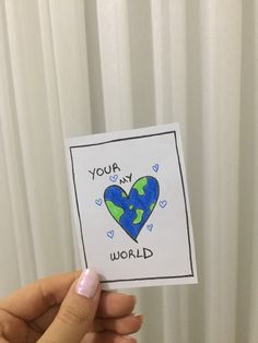 someone holding up a card that says you're my world with a heart on it