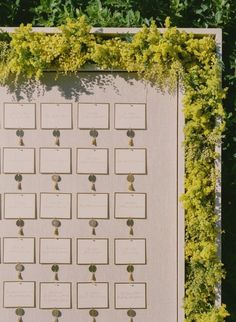 the seating chart is covered with flowers and greenery