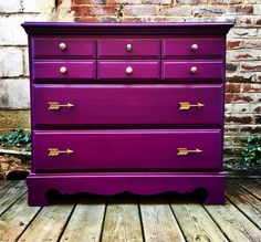 a purple dresser sitting on top of a wooden floor