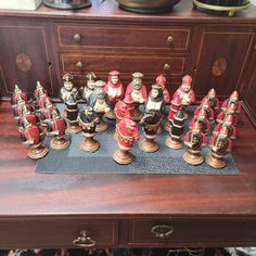 a collection of figurines sitting on top of a wooden table next to a dresser