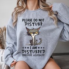 a woman wearing a sweatshirt that says please don't disturb i am disturbed enough already