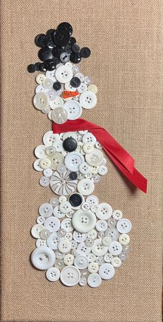 a snowman made out of buttons on a piece of burlock