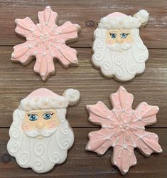 three decorated cookies in the shape of santa claus