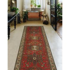 a large red rug is in the middle of a room with white walls and windows