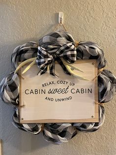 a sign hanging from the side of a door that says relax cozy up cabin sweet cabin and unwind