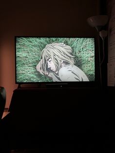 a tv sitting on top of a table in front of a wall with writing on it