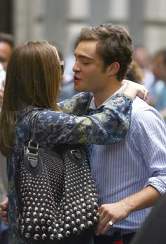 a man and woman embracing each other in the street