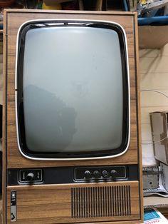 an old tv sitting on top of a wooden stand