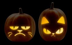 two carved pumpkins with faces and eyes lit up in the dark, one has a cat's face on it