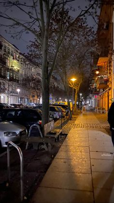 a man walking down the sidewalk at night