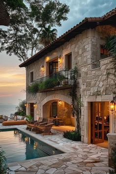 an outdoor swimming pool next to a stone building