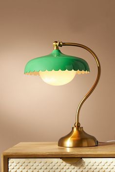 a green lamp sitting on top of a wooden table