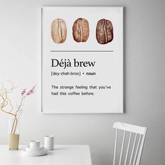 a white table topped with two coffee cups and a framed poster above it that says, deja brew