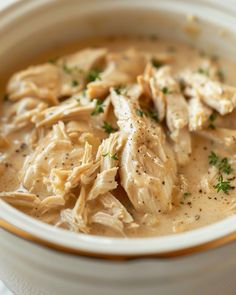 a white bowl filled with chicken and gravy