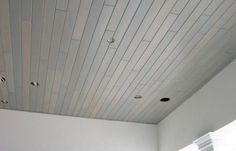 an empty room with white walls and wood flooring on the ceiling is seen in this image