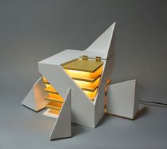 a lamp that is sitting on top of a white object with yellow light coming out of it