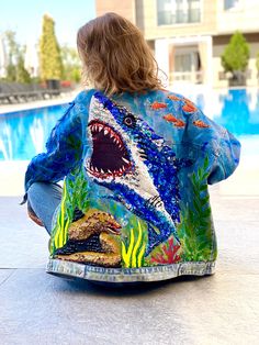 Here you can see customized denim jacket with hand embroidered  Shark, sea Moray and Turtle . Jean jacket with a picture - inspired by Deep dark ocean creatures.      This is 100% Hand embroidered clothing (not machine embroidery) . Such illustration is an original artwork hand embroidered by me. Jewelry work.       Please look at all details of this huge art work on photos attached. This hand embroidered jacket create with a million details and it has amazing shining and sparkling effect on the sun . It's absolutely amazing effect! This is a real wearable art and one of the kind customized denim jacket for women. It's a perfect custom gift for her.  THIS DENIM JACKET IS ONE-OF-A-KIND, NO COPIES ALLOWED. ----------------------------------- IMPORTANT! Before PURCHASE , check out the details Fish Clothes, Customized Denim, Embellished Jackets, Huge Art, Punk Jacket, Dark Ocean, Gothic Jackets, Embroidered Jean Jacket, Embellished Denim Jacket