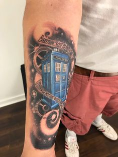 a man with a tattoo on his arm has a blue tardish in space