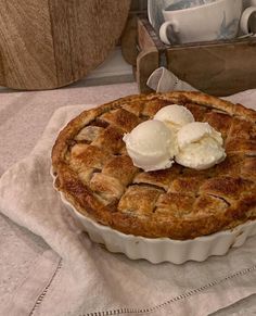 a pie with two scoops of ice cream sitting on top of a white cloth