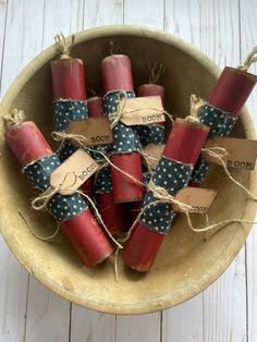 small red candles wrapped in twine and tied with burlocks are sitting in a bowl