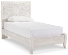 a white bed with an intricate headboard and foot board on it's side