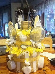 a cake made out of utensils and yellow flowers on a table with remote controls