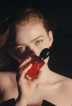 a woman holding a red object in her mouth