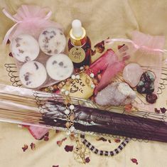 an assortment of items are displayed on a table with pink flowers and ribbons around them