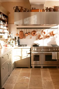 a kitchen with pots and pans hanging on the wall above the stove top oven